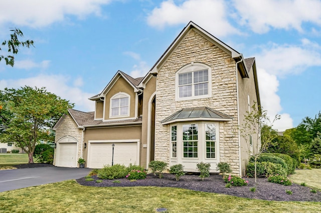 view of property featuring a garage and a front lawn