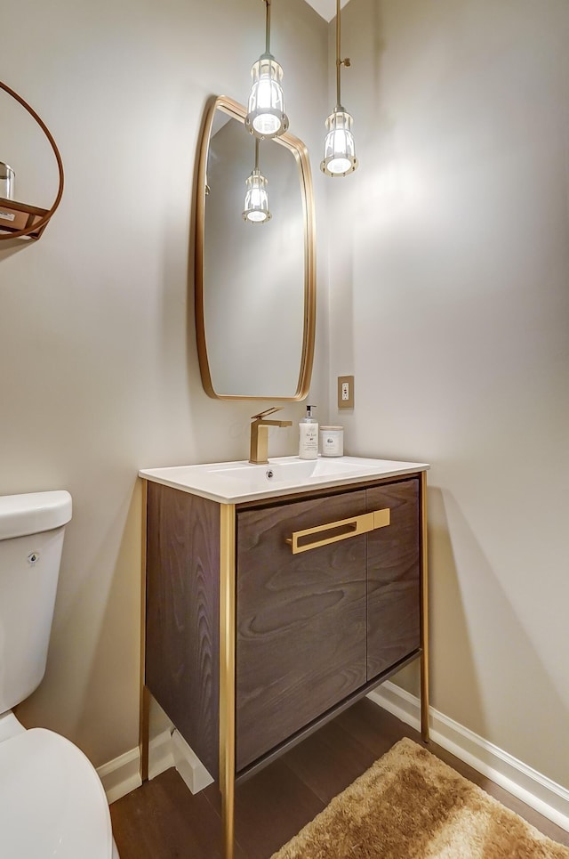 bathroom featuring vanity, hardwood / wood-style flooring, and toilet