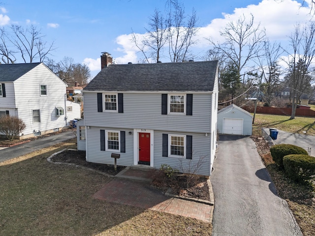 view of front of house with a garage, an outdoor structure, and a front yard