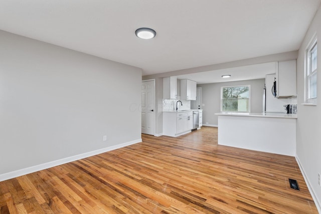 unfurnished living room with sink and light wood-type flooring