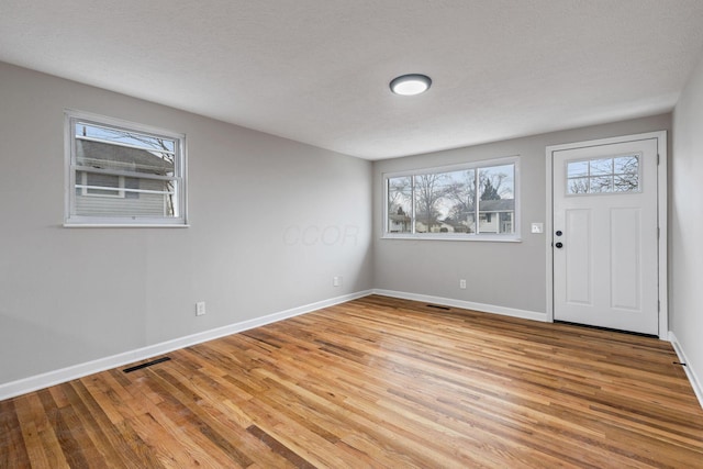 foyer with wood-type flooring and a textured ceiling