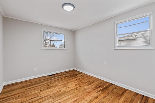 empty room featuring ornamental molding and light hardwood / wood-style floors