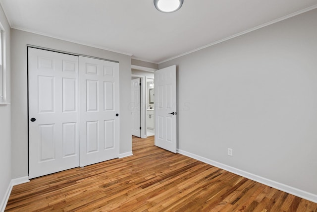 unfurnished bedroom with ornamental molding, a closet, and light hardwood / wood-style flooring