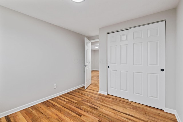 unfurnished bedroom with a closet and light hardwood / wood-style flooring