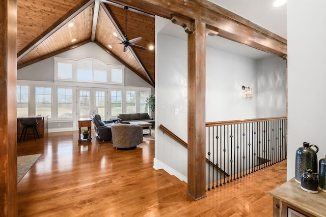 interior space with baseboards, ceiling fan, wood ceiling, beam ceiling, and wood finished floors