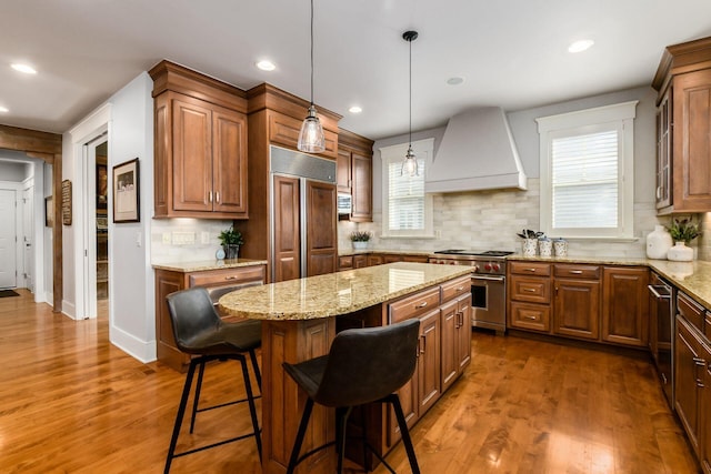 kitchen featuring premium appliances, custom exhaust hood, dark wood finished floors, and a center island