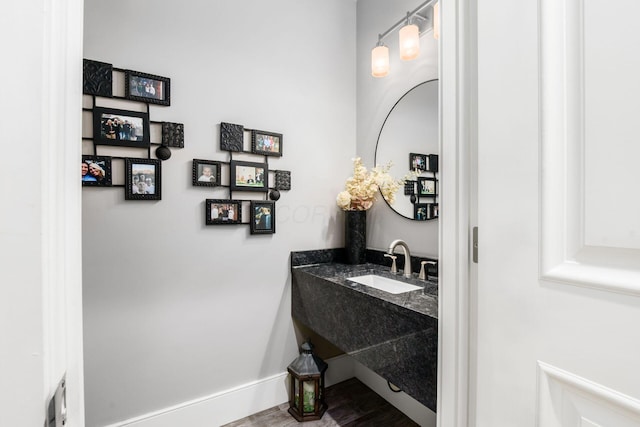 bathroom featuring baseboards, wood finished floors, and vanity