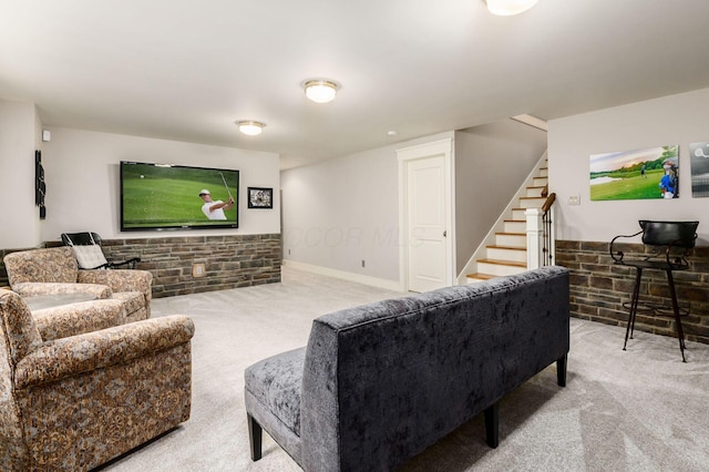 carpeted living room featuring stairway and brick wall