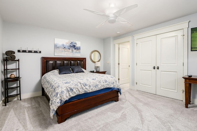 carpeted bedroom with a closet, ceiling fan, and baseboards