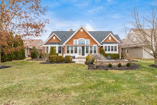 back of property featuring a patio, a yard, a shingled roof, entry steps, and a chimney