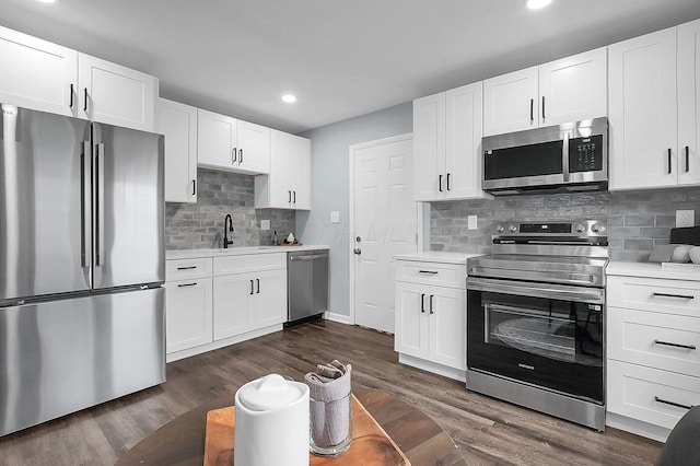 kitchen with stainless steel appliances, white cabinetry, sink, and dark hardwood / wood-style floors