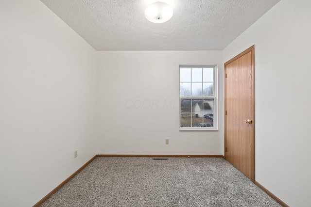 spare room featuring a textured ceiling and carpet flooring