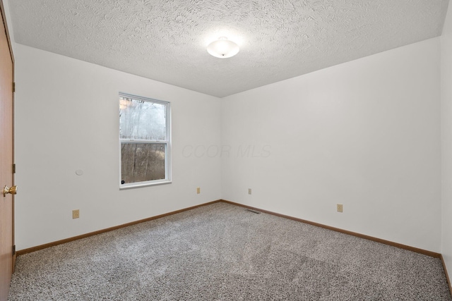 carpeted spare room with a textured ceiling