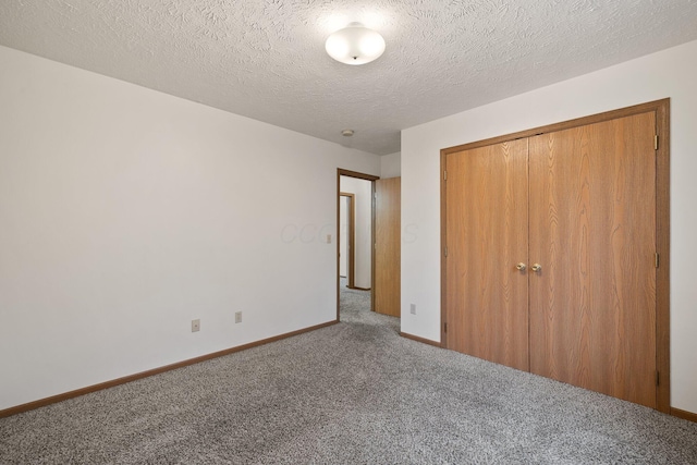 unfurnished bedroom featuring carpet floors, a closet, and a textured ceiling