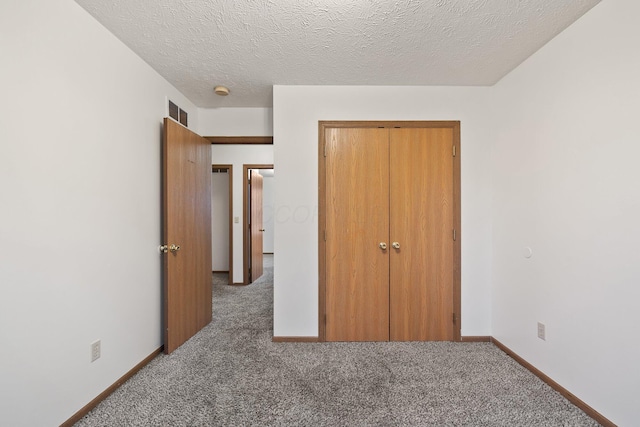 unfurnished bedroom with a closet, a textured ceiling, and carpet flooring