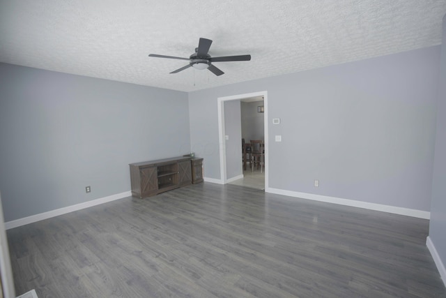 unfurnished room featuring dark wood finished floors, a textured ceiling, and baseboards