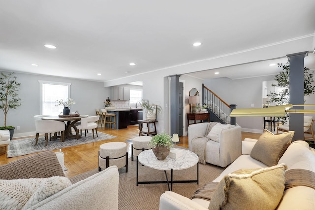 living room featuring light wood-type flooring and ornate columns