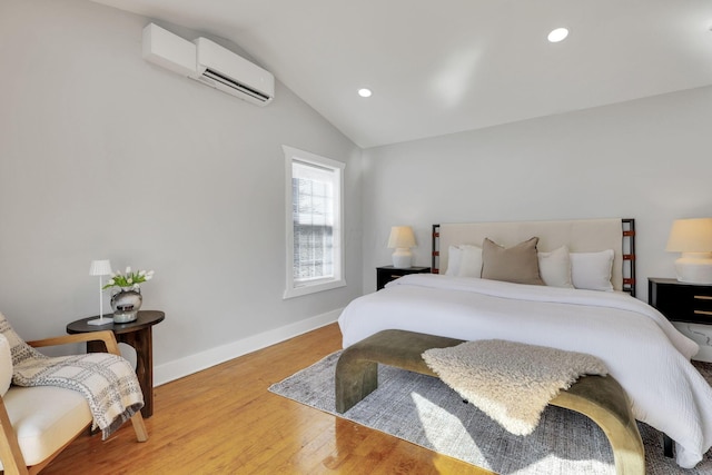 bedroom featuring a wall mounted air conditioner, hardwood / wood-style flooring, and lofted ceiling