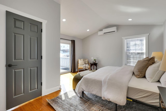 bedroom with light hardwood / wood-style flooring, a wall unit AC, access to exterior, and lofted ceiling