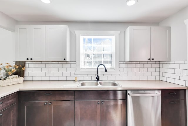 kitchen with sink, dishwasher, white cabinetry, and decorative backsplash