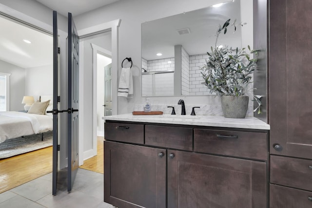 bathroom featuring decorative backsplash, vanity, and a shower with door