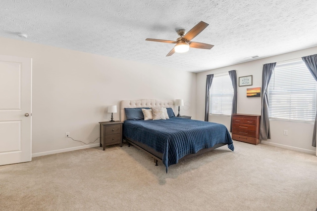 carpeted bedroom with ceiling fan and a textured ceiling