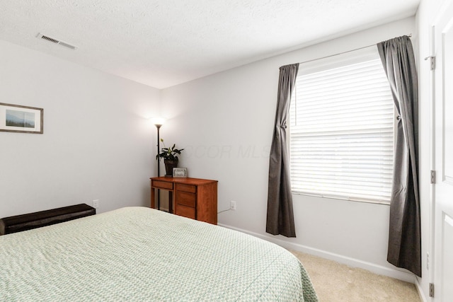 carpeted bedroom featuring a textured ceiling