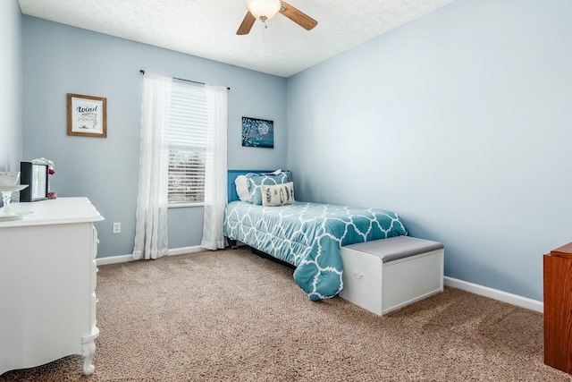 carpeted bedroom featuring a textured ceiling, a ceiling fan, and baseboards