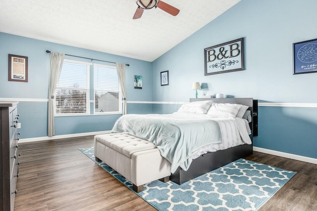 bedroom with lofted ceiling, dark wood-type flooring, a textured ceiling, and baseboards