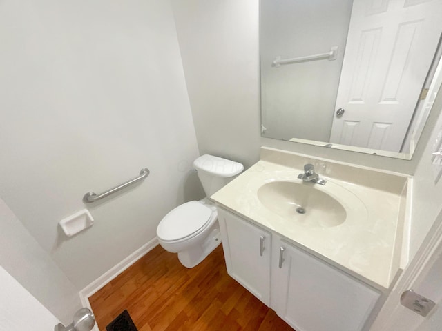 bathroom with hardwood / wood-style flooring, vanity, and toilet