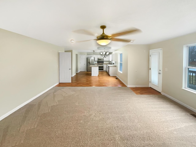 unfurnished living room featuring ceiling fan and light colored carpet