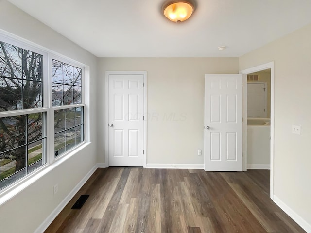 unfurnished bedroom with dark hardwood / wood-style floors