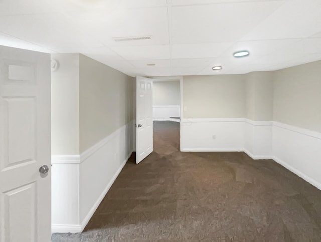 carpeted empty room with a paneled ceiling