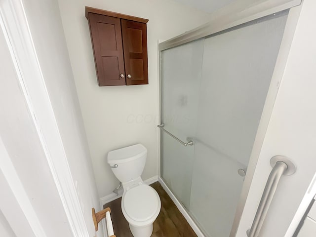 bathroom with hardwood / wood-style flooring, toilet, and walk in shower