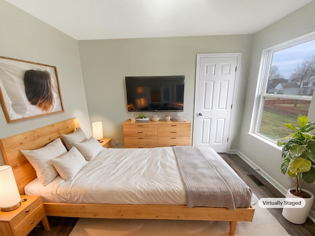 bedroom with dark hardwood / wood-style flooring