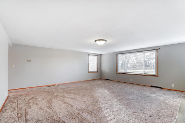 spare room featuring light carpet