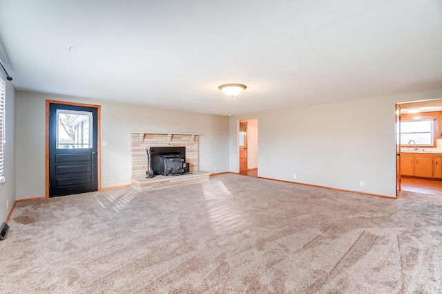 unfurnished living room featuring carpet floors and sink