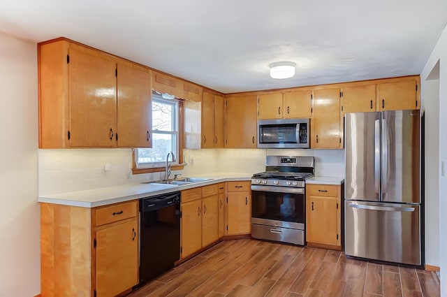 kitchen featuring appliances with stainless steel finishes, sink, backsplash, and light hardwood / wood-style floors