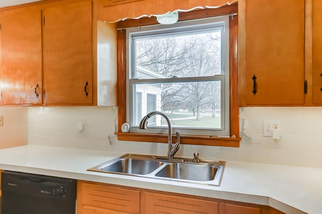 kitchen featuring sink, decorative backsplash, plenty of natural light, and black dishwasher