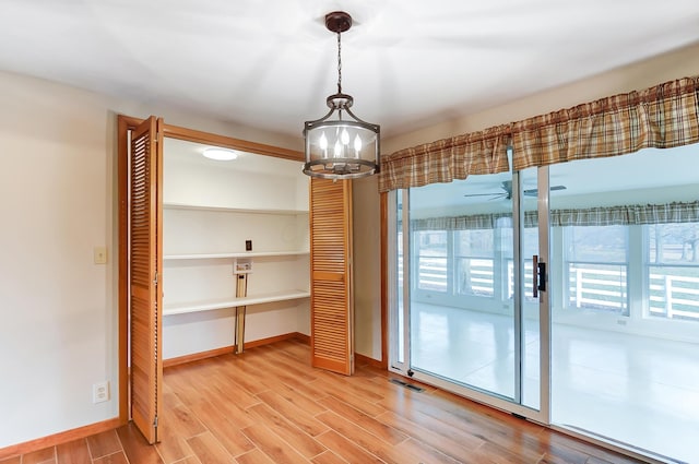 unfurnished dining area featuring ceiling fan and hardwood / wood-style floors