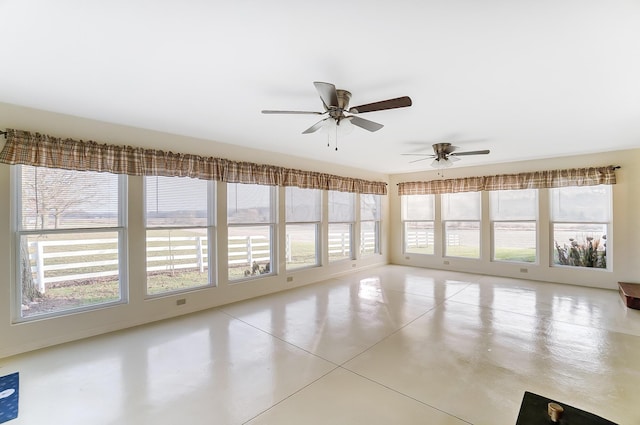 unfurnished sunroom with ceiling fan