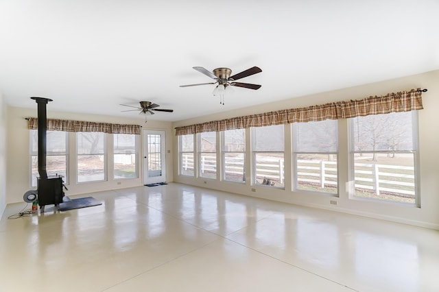 interior space featuring ceiling fan and a wood stove