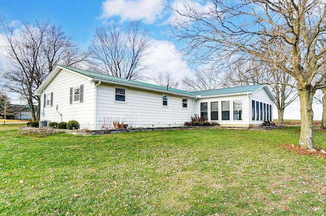 back of house featuring a sunroom, a yard, and cooling unit