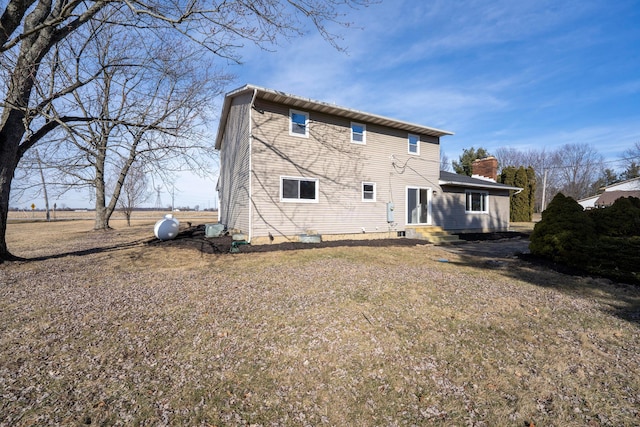 rear view of house featuring a lawn