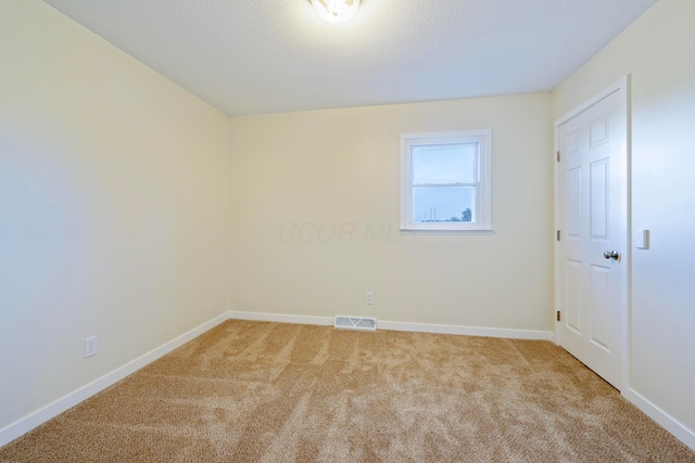 spare room featuring light colored carpet