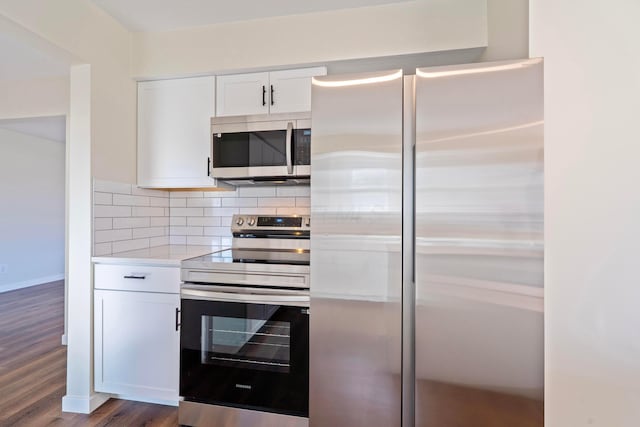 kitchen with white cabinetry, appliances with stainless steel finishes, dark hardwood / wood-style floors, and tasteful backsplash