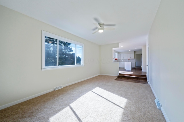 unfurnished living room with carpet flooring and ceiling fan