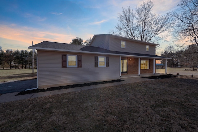 back house at dusk with covered porch