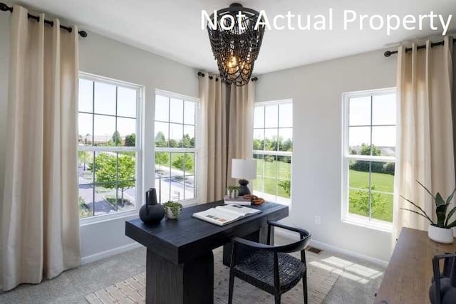 home office with carpet, a wealth of natural light, and a notable chandelier