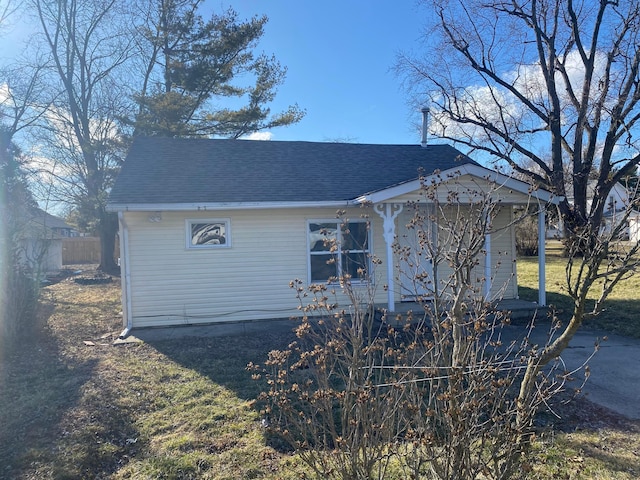 exterior space featuring fence, a porch, and roof with shingles